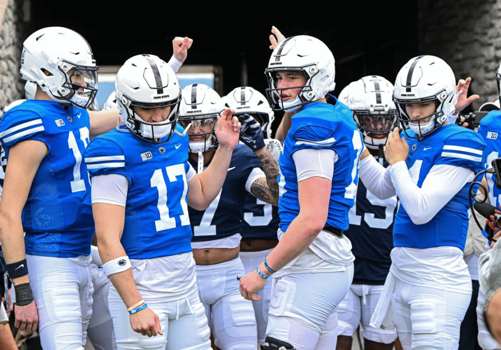 Penn State Nittany Lions football team in a pre-game huddle wearing their blue and white uniforms 